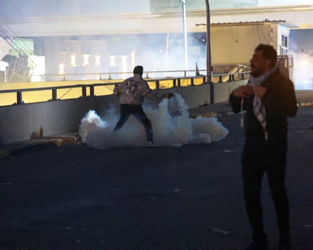 A man prepares to throw a smoke grenade