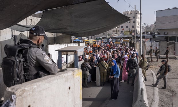 Palestinians queue at a checkpoint