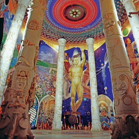 A large reception space at the underground temples of Damanhur in Italy. The wall is covered in a brightly painted human figure mural.