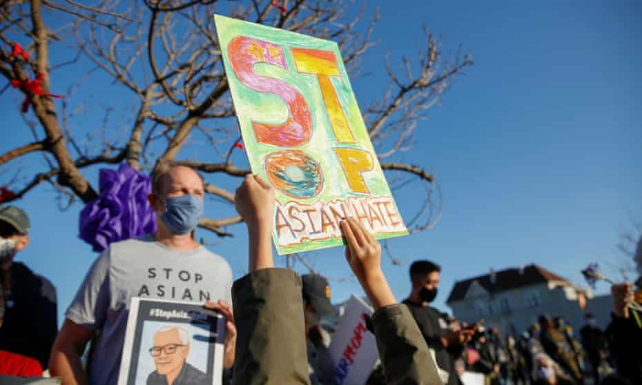 A six-year-old holds up a hand-drawn sign that reads ‘Stop Asian hate’ in Oakland, California, on 23 March. 
