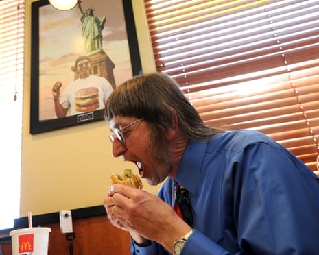 A man bites into a McDonald's burger.