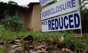 A foreclosure/price reduced sign stands at a home for sale in Miami, Florida.