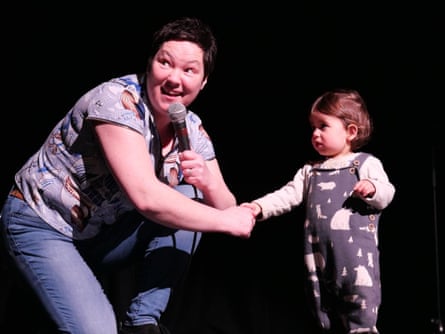 Comedian Julie Jepson onstage with child.