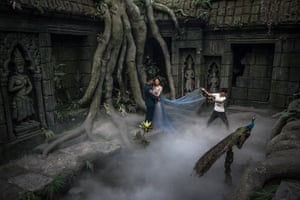 A couple pose for their pre-wedding photos in an interior made to look like Angkor Wat