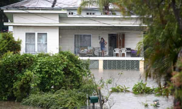 A resident watches floodwaters from his house in Ipswich.