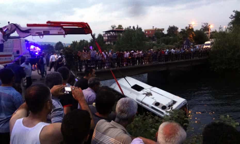 Civilians try to rescue people from a bus, carrying primary school students, teachers and parents, toppling over irrigation channel in Osmaniye.