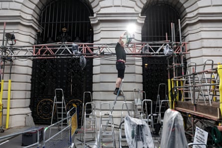 A man sets up a spotlight on a scaffold