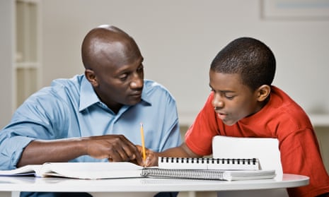 A man helps a boy with his homework