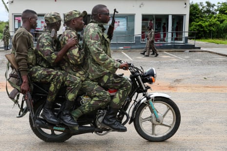 Mozambique army soldiers take a ride on a motorbike in the streets of Palma, Cabo Delgado.