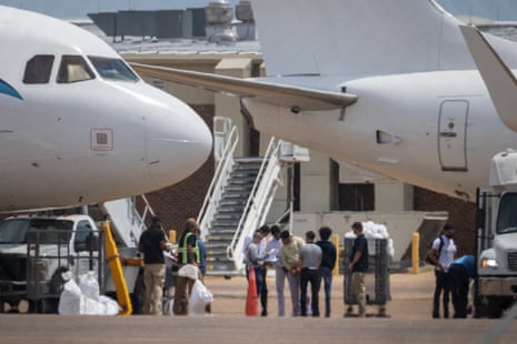 people stand between airplanes