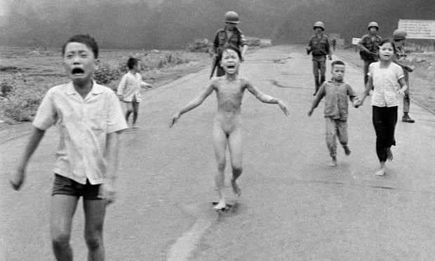 South Vietnamese forces follow terrified children, including Kim Phuc (C) as they run away after a napalm attack.