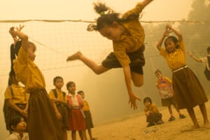 Children play without wearing any protection from the haze
