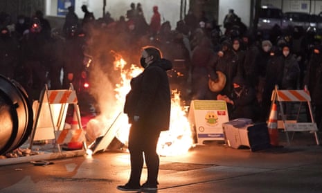 A protester walks past burning trash during a protest against police brutality in downtown Tacoma.
