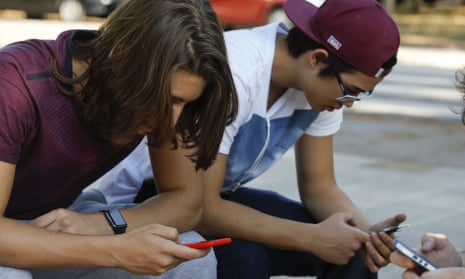 Youth check their cell phones in Sao Paulo, Brazil