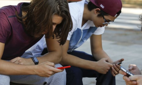 Teenagers check their mobiles in São Paulo, Brazil