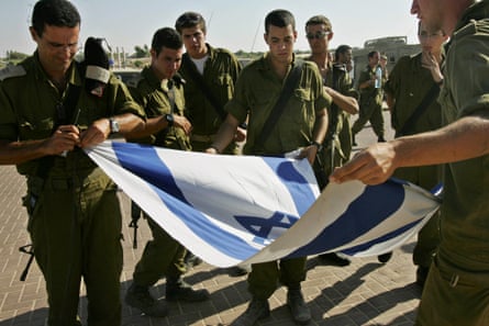 Israeli soldiers fold the national flag during a ceremony at the evacuated Gaza settlement of Atzmona in September 2005.