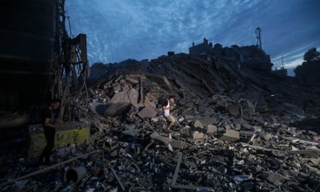 Palestinians inspect the destroyed surrounding of the Palestine Tower after Israeli warplanes targeted it in Gaza City.