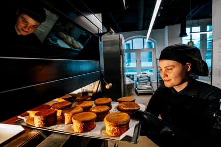 Chef holds tray with circular piles of baked laminated dough
