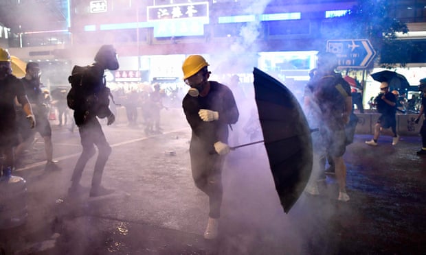 Protesters try to avoid tear gas let off by police.