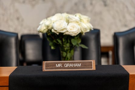 An empty chair, white roses and a Mr. Grahm nameplate