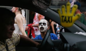 A boy dressed as a zombie gestures at a taxi driver
