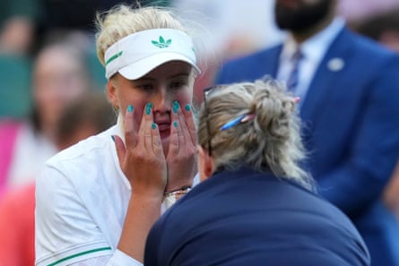 Clara Tauson receives medical assistance during her fourth-round match against Iga Swiatek.