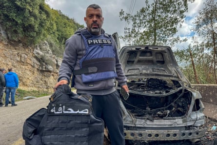 Jamal al-Ghurabi, a journalist for al-Mayadeen, holds up press vests removed from the car.
