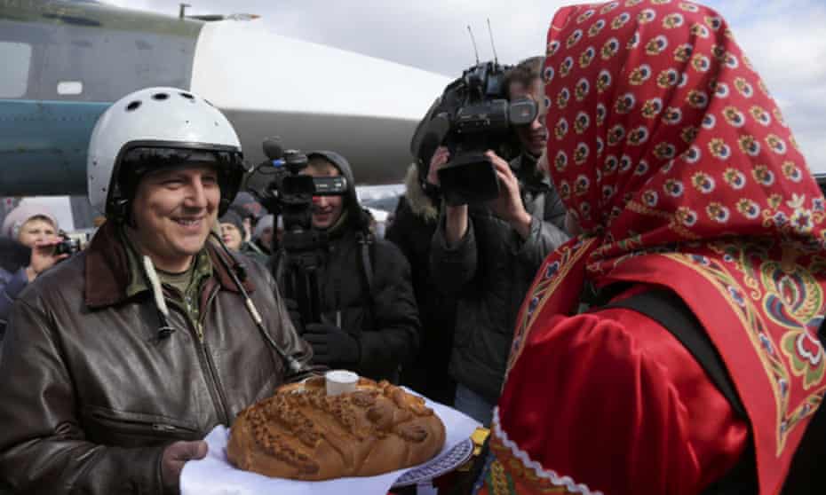 A Russian pilot returns from Syria to a traditional welcome of bread and salt at an airbase near Voronezh.