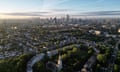 An aerial view at sunrise of housing in Islington, north London, with the City of London and Canary Wharf on the horizon.