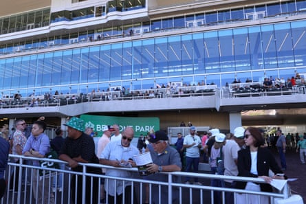 fans stand at a racetrack