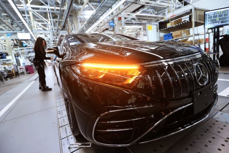 An employee checks a Mercedes-Benz electric vehicle on the assembly line in Sindelfingen, Germany