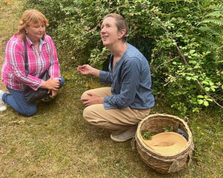 Wild food expert Liz Knight of Forage Fine Foods crouches beside some foliage in the Herefordshire countryside as she explains about foraging for fruit and herbs to the writer and other guests.