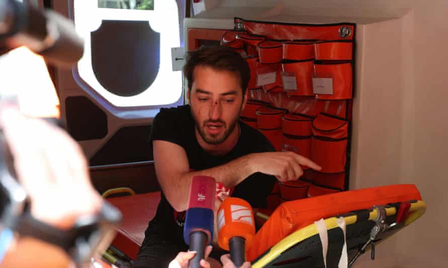 An injured journalist speaks to the media inside an ambulance in Tbilisi.