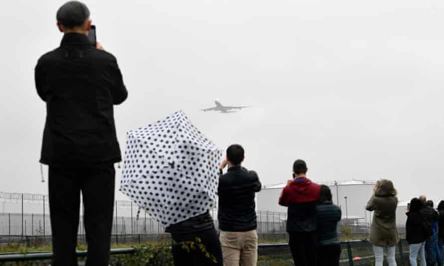 Onlookers take pictures of one of the departing planes