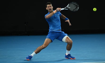 Novak Djokovic, with a strapped left thigh, watches the ball fly back towards Grigor Dimitrov