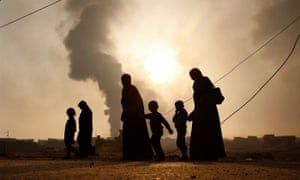 A family walks away from the front line in Mosul, Iraq