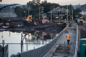 Workers clear debris from the new Windsor bridge which was underwater during the recent floods