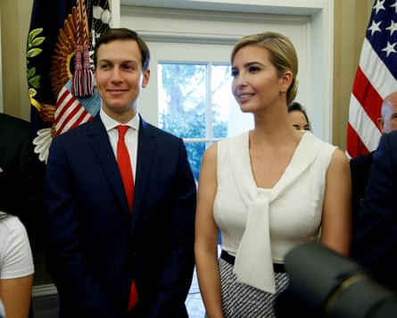 Jared Kushner wearing a red tie standing next to his wife Ivanka in a white top.