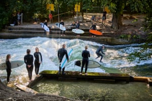 Surfers ride waves on the Eisbach in the English Garden