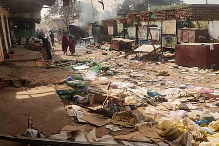 People walk among scattered debris in a destroyed market