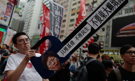 A protester holds a sign in the shape of a chainsaw with an image of Hong Kong chief executive Carrie Lam during a land reclamation protest in Hong Kong on Sunday.