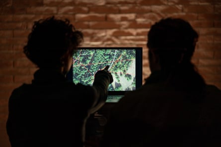 Silhouettes of two people looking at a screen