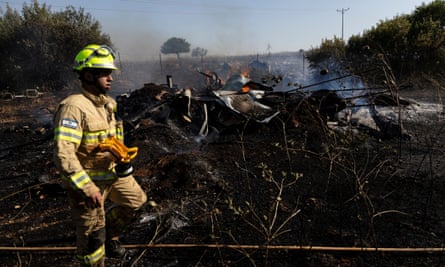 A firefighter in uniform near scorched earth