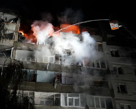 A burning building and firefighters working