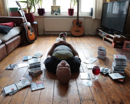 Rich Pelley lying on the floor at home, in a pose similar to the Oasis album cover for Definitely Maybe.