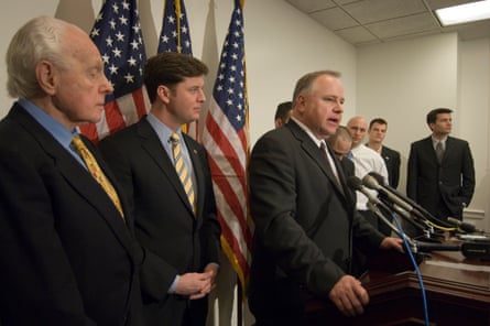 group of men behind a podium, with walz at the mic
