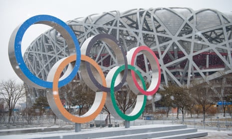 The Olympic rings and the National Stadium amid snowfall in Beijing