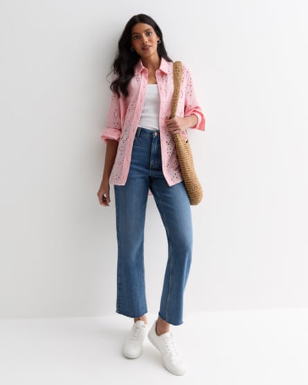 Model wearing blue jeans and a pink broderie anglaise shirt