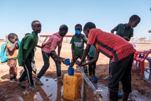Children collect water at a school in the camp for internally displaced people of Farburo