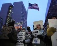 people outside hold up signs in protest